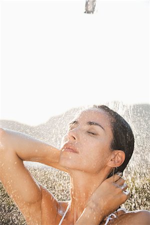 Mid femme jouissant de douche en plein air avec les yeux fermés Photographie de stock - Premium Libres de Droits, Code: 632-05845576