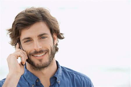 Homme à l'aide de téléphone portable à l'extérieur, sourire, portrait Photographie de stock - Premium Libres de Droits, Code: 632-05845746
