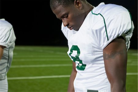 Football player looking down in disappointment Stock Photo - Premium Royalty-Free, Code: 632-05991373