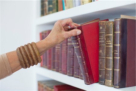 Woman choosing book from bookshelf, cropped Stock Photo - Premium Royalty-Free, Code: 632-05992024