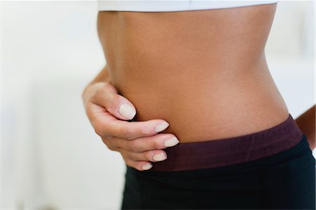 female tummy - Woman holding stomach, mid section Stock Photo - Premium Royalty-Free, Code: 632-05992167