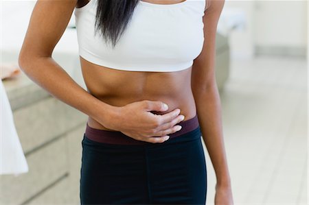 stomach ache in women - Woman experiencing abdominal pain, mid section Stock Photo - Premium Royalty-Free, Code: 632-05992207