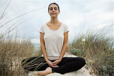 Smiling mature woman meditating on beach, portrait Stock Photo - Premium Royalty-Free, Code: 632-05992244