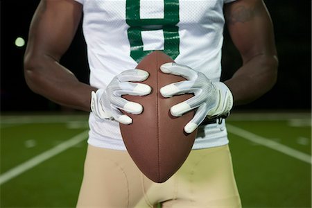football (american ball) - Football player holding football, cropped Foto de stock - Sin royalties Premium, Código: 632-05992297