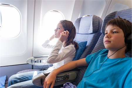 simsearch:632-06029740,k - Children watching movie on airplane with headphones Stock Photo - Premium Royalty-Free, Code: 632-06029537