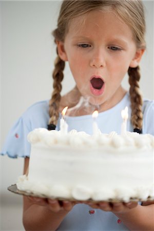 simsearch:632-05604245,k - Girl blowing out candles on birthday cake Stock Photo - Premium Royalty-Free, Code: 632-06029624