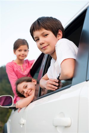 Siblings leaning out of car window, smiling, portrait Stock Photo - Premium Royalty-Free, Code: 632-06029631