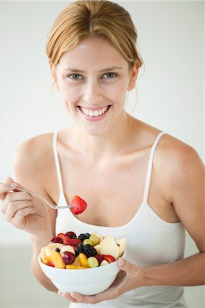 Young woman eating bowl of fruit, portrait Foto de stock - Sin royalties Premium, Código: 632-06029870