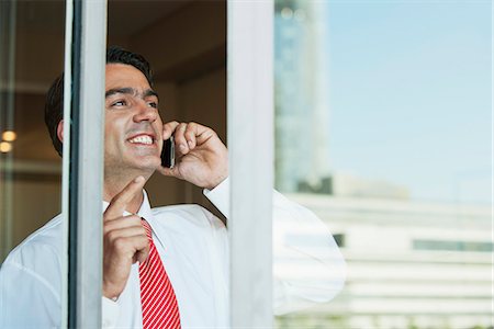 simsearch:632-05604036,k - Businessman using cell phone in office, seen from outside of window Stock Photo - Premium Royalty-Free, Code: 632-06118165