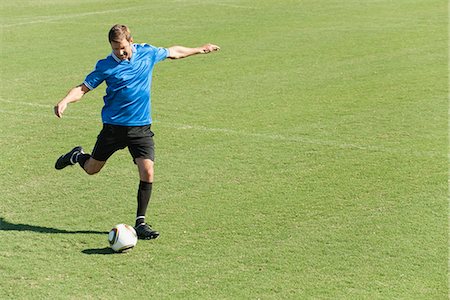 Soccer player kicking soccer ball on soccer field Stock Photo - Premium Royalty-Free, Code: 632-06118248