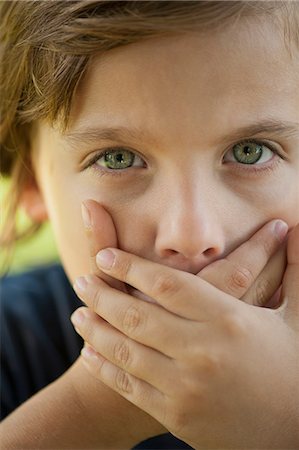 Boy covering mouth with hands Stock Photo - Premium Royalty-Free, Code: 632-06118301