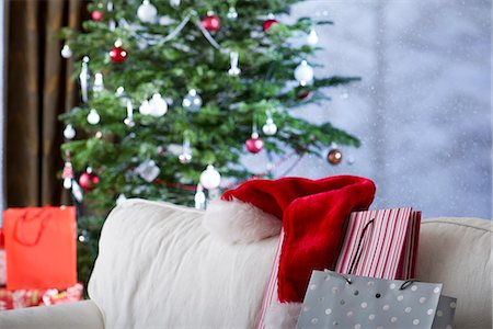 santa claus-mütze - Weihnachtsgeschenke und Nikolausmütze auf sofa Stockbilder - Premium RF Lizenzfrei, Bildnummer: 632-06118927