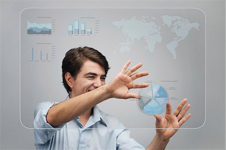 Businessman using advanced touch screen technology to view sales data Stock Photo - Premium Royalty-Free, Code: 632-06317132