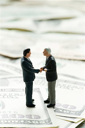 stack of money - Male figurines shaking hands on pile of one hundred dollar bills Stock Photo - Premium Royalty-Free, Code: 632-06317326