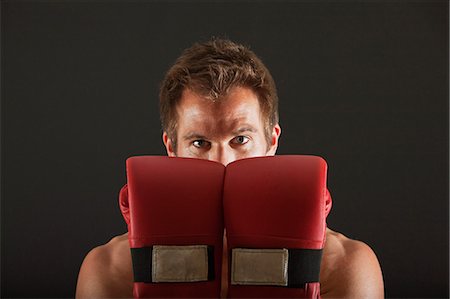 simsearch:632-05991588,k - Boxer holding up gloves in front of face in defensive position Stock Photo - Premium Royalty-Free, Code: 632-06317406
