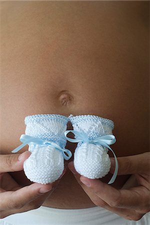 pregnant belly button - Pregnant woman holding baby booties, cropped Stock Photo - Premium Royalty-Free, Code: 632-06317768