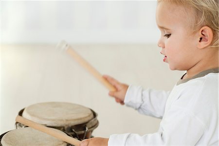 rhythm - Baby boy playing drums, side view Stock Photo - Premium Royalty-Free, Code: 632-06354108