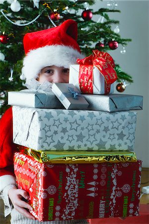 Boy holding stack of Christmas presents Stock Photo - Premium Royalty-Free, Code: 632-06354208