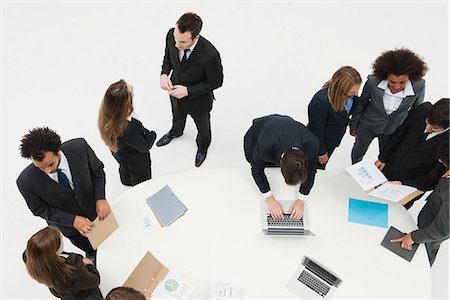 Business associates working together in small groups around table Stock Photo - Premium Royalty-Free, Code: 632-06354339