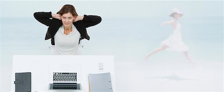 escapism - Mature businesswoman sitting at desk, imagining herself at the beach Stock Photo - Premium Royalty-Free, Code: 632-06354448