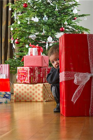 picture baby christmas - Baby girl hiding behind Christmas present Stock Photo - Premium Royalty-Free, Code: 632-06353946