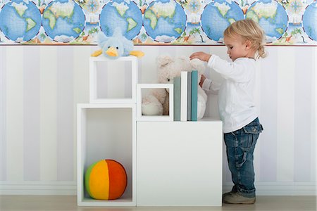 Baby boy standing by shelves with toys Stock Photo - Premium Royalty-Free, Code: 632-06779232