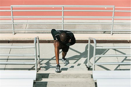 Man stretching legs on bleachers Stock Photo - Premium Royalty-Free, Code: 632-06779297