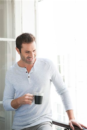 Man standing by window with mug in hand Stock Photo - Premium Royalty-Free, Code: 632-07674627