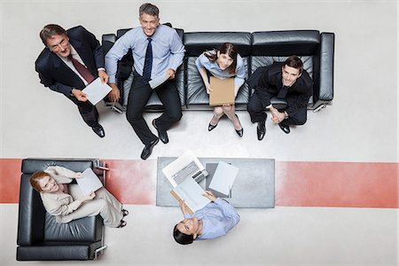 reporting - Executives in meeting, smiling at camera, overhead view Stock Photo - Premium Royalty-Free, Code: 632-07809427