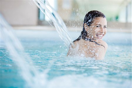 simsearch:6108-06907511,k - Woman relaxing under fountain in swimming pool Stock Photo - Premium Royalty-Free, Code: 632-07809529