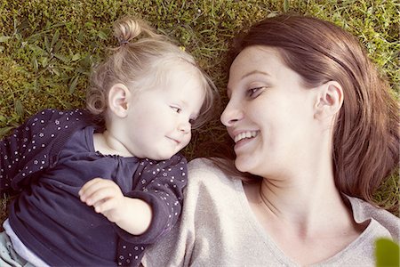 smiling baby portrait - Mother and baby girl lying on grass, smiling at each other Stock Photo - Premium Royalty-Free, Code: 632-07849468