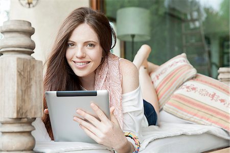 Young woman lying on stomach with digital tablet, portrait Foto de stock - Sin royalties Premium, Código: 632-08001794