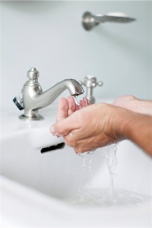 simsearch:632-05816631,k - Man cupping hands beneath water running from bathroom faucet Stock Photo - Premium Royalty-Free, Code: 632-08001874