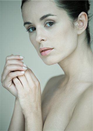 simsearch:632-05760692,k - Woman with bare shoulders, hands clasped near face, portrait Stock Photo - Premium Royalty-Free, Code: 632-08130175