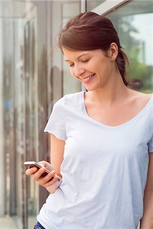 simsearch:632-05760692,k - Woman using smartphone outdoors, smiling Stock Photo - Premium Royalty-Free, Code: 632-08130340