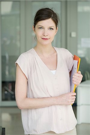 Woman carrying folders, smiling, portrait Stock Photo - Premium Royalty-Free, Code: 632-08130369