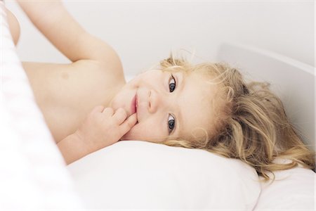 finger in mouth - Little girl lying down with finger in mouth, portrait Stock Photo - Premium Royalty-Free, Code: 632-08227425