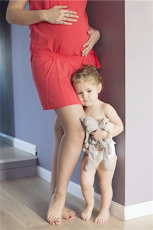 Little girl clinging to her pregnant mother's leg with worried expression on face Foto de stock - Sin royalties Premium, Código: 632-08227479