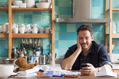 family kitchen - Man at home using smartphone Stock Photo - Premium Royalty-Free, Code: 632-08227490