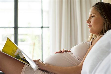 pregnant low angle - Pregnant woman reading magazine in bed Stock Photo - Premium Royalty-Free, Code: 632-08227616