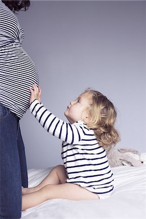 pregnant low angle - Little girl touching mother's pregnant stomach, cropped Stock Photo - Premium Royalty-Free, Code: 632-08227654