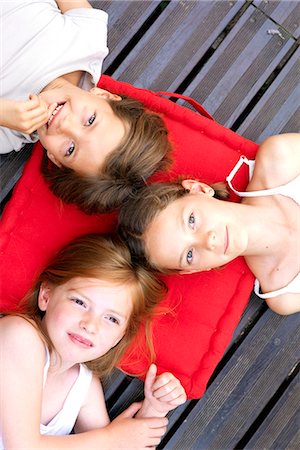 simsearch:632-06030215,k - Girls lying down outdoors with heads resting on shared cushion Stock Photo - Premium Royalty-Free, Code: 632-08227714