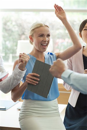 Businesswoman celebrating success with colleagues Stock Photo - Premium Royalty-Free, Code: 632-08227853