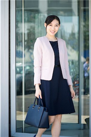 simsearch:632-05401320,k - Businesswoman exiting building, smiling cheerfully Stock Photo - Premium Royalty-Free, Code: 632-08331634