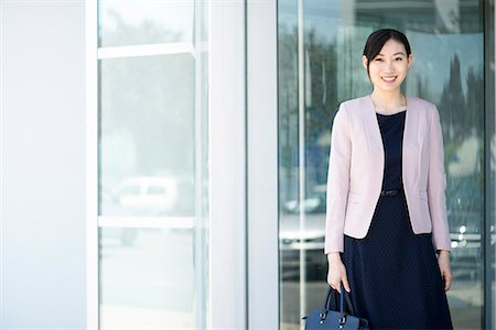 simsearch:632-05401320,k - Businesswoman standing in front of office building, smiling, portrait Stock Photo - Premium Royalty-Free, Code: 632-08331633