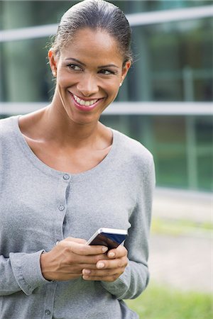simsearch:632-05760692,k - Woman using smartphone and smiling outdoors Stock Photo - Premium Royalty-Free, Code: 632-08331656
