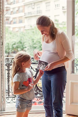 showing - Mother preparing daughter for arrival of her new sibling Stock Photo - Premium Royalty-Free, Code: 632-08545873