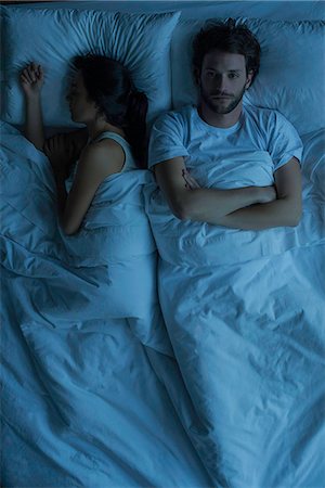 simsearch:649-07521015,k - Man lying awake in bed next to sleeping wife Stock Photo - Premium Royalty-Free, Code: 632-08698338