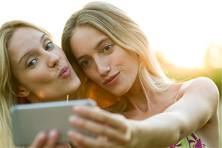 simsearch:632-07674444,k - Couple posing cheek to cheek for smartphone selfie Stock Photo - Premium Royalty-Free, Code: 632-08698357