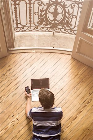 simsearch:632-05400935,k - Man lying on floor using laptop and smartphone Stock Photo - Premium Royalty-Free, Code: 632-08698381